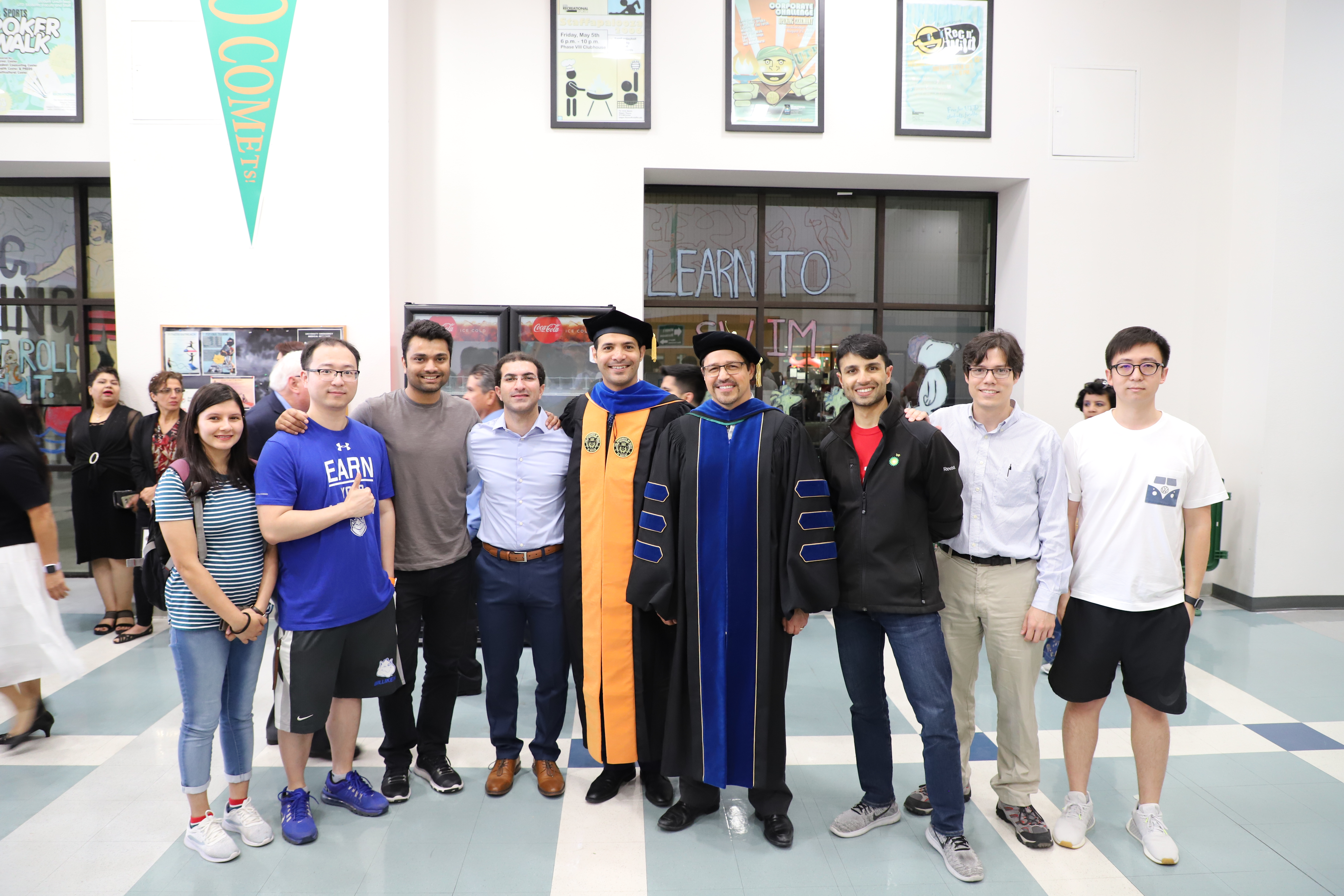  Malik and eight others pose together at a graduation ceremony.